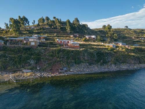 a group of houses on a hill next to the water at Posada de Oliver in Llachon