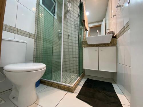 a bathroom with a toilet and a glass shower at ITAPARICA BEACH 24HRS in Vila Velha