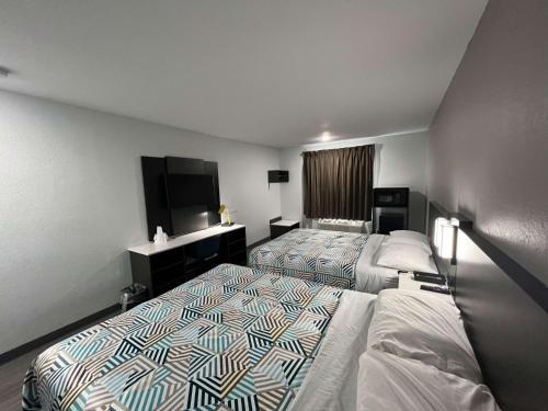 ein Hotelzimmer mit 2 Betten und einem Flachbild-TV in der Unterkunft Motel 6-Altoona, IA - Des Moines East in Altoona