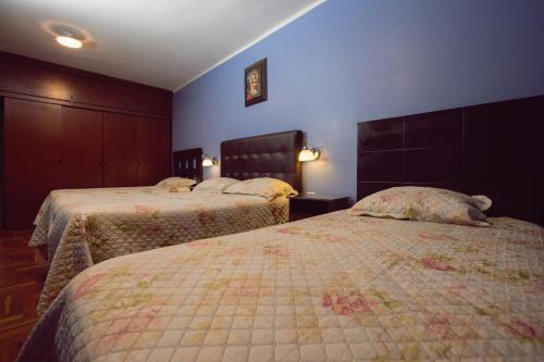 a hotel room with two beds with a stuffed animal laying on them at Hospedaje Zaragoza in Ayacucho