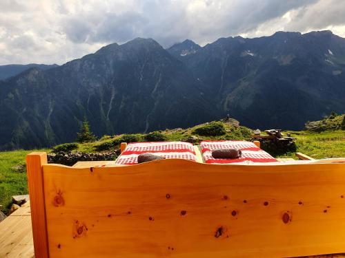 a wooden bed on top of a mountain at Rifugio Alpe San Romerio in Brusio