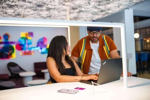 a man and a woman looking at a laptop at YOTEL Washington DC in Washington