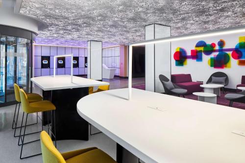 an office with white tables and chairs and purple ceilings at YOTEL Washington DC in Washington