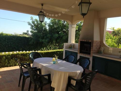 a table and chairs on a patio with a fireplace at Casa Alfazema - Villa Algarvia de Charme in Pechão