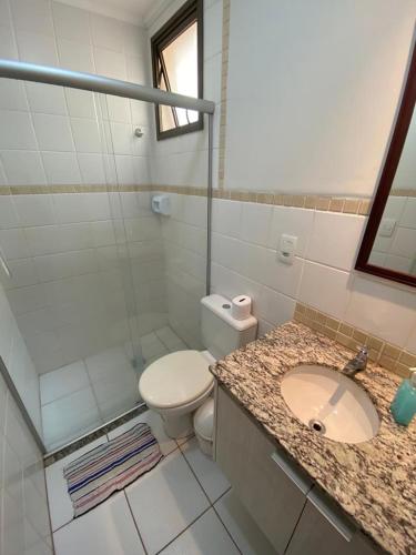 a bathroom with a toilet and a sink and a shower at Apto a 3 minutos do Thermas!! in Olímpia