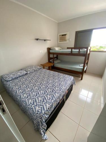 a bedroom with a bed and a bunk bed at Apto a 3 minutos do Thermas!! in Olímpia