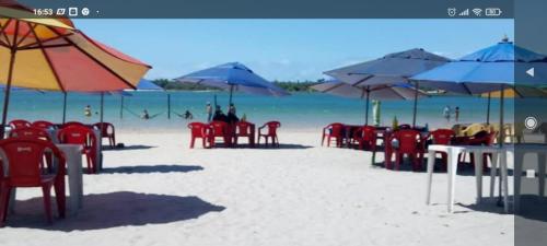 a group of chairs and umbrellas on a beach at CASA Praia Barra de Tabatinga NATAL RN in Nísia Floresta