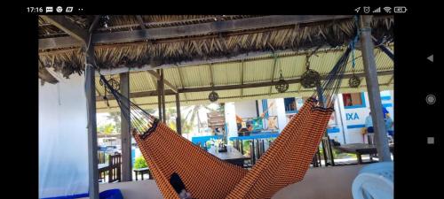 two hammocks hanging from a thatched roof in a room at CASA Praia Barra de Tabatinga NATAL RN in Nísia Floresta