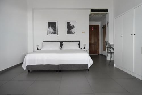 een slaapkamer met een groot wit bed met 2 foto's aan de muur bij Villa Palma in Tučepi