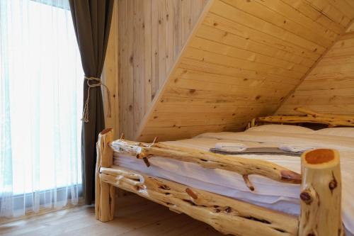 a bedroom with a bed in a wooden room at Drvena Kuca RUŽA in Kopaonik