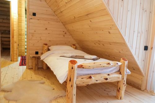 a bed in a wooden room in a attic at Drvena Kuca RUŽA in Kopaonik