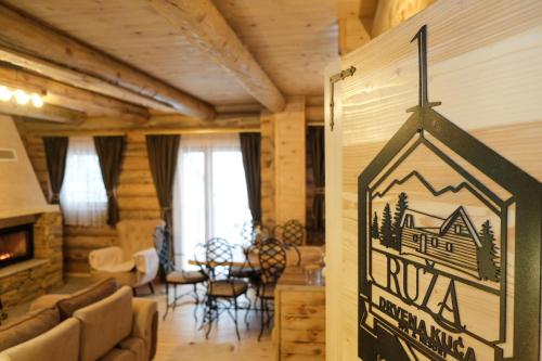 a living room with a sign on the wall at Drvena Kuca RUŽA in Kopaonik