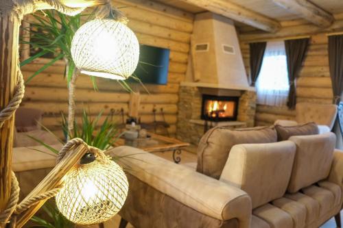 a living room with a couch and a fireplace at Drvena Kuca RUŽA in Kopaonik