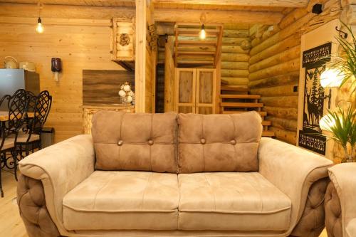 a brown couch in a room with a table at Drvena Kuca RUŽA in Kopaonik