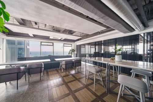 a bar with chairs and tables in a room with windows at Elysia Boutique Hotel in Busan