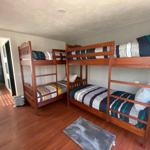 a room with three bunk beds and a wooden floor at Casa boutique ROMA in Mineral del Monte