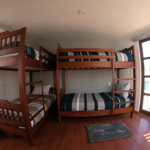 a room with three bunk beds and a window at Casa boutique ROMA in Mineral del Monte