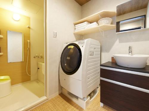 y baño con lavadora y lavamanos. en Kyomachiya Gion Kanau en Kyoto