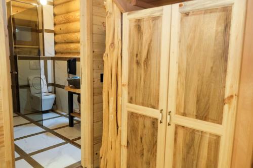 a pair of wooden doors in a bathroom at Drvena Kuca RUŽA in Kopaonik