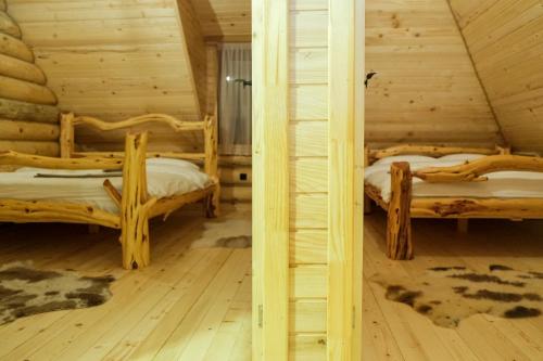 a room with two beds in a log cabin at Drvena Kuca RUŽA in Kopaonik