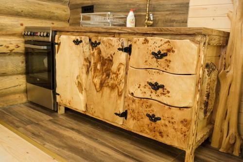 a wooden cabinet in a kitchen next to a stove at Drvena Kuca RUŽA in Kopaonik