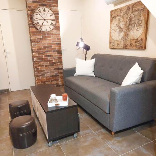 un salon avec un canapé et une horloge au mur dans l'établissement VILLA REIALA Chaville, à Chaville