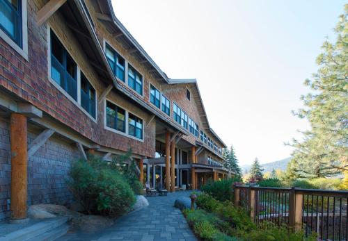 a brick building with a fence next to a sidewalk at Sun Mountain Lodge in Winthrop