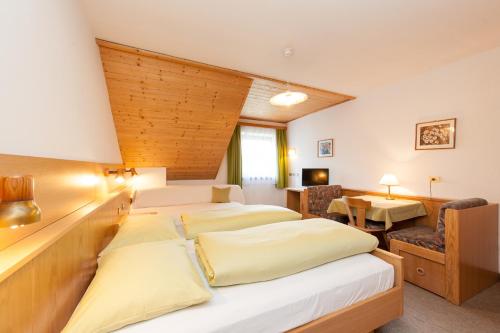 a hotel room with two beds and a table at Residence Pichlerhof in Rasun di Sopra