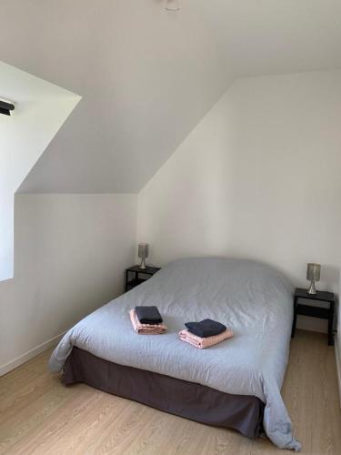 a bedroom with a bed with two towels on it at Les écuries du Nevez in Plonéour-Lanvern