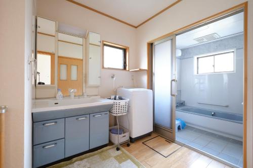 a bathroom with a tub and a sink and a shower at Ichiya no jikka / Vacation STAY 78859 in Shimosato