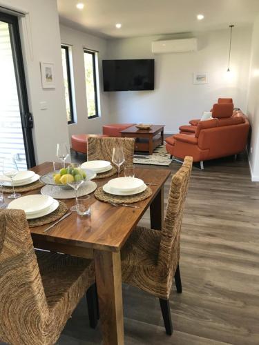 a dining room with a wooden table and chairs at Gillys Guesthouse in Metung