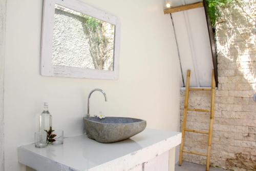La salle de bains est pourvue d'un lavabo en pierre sur un comptoir. dans l'établissement LUCKY'S, à Gili Air