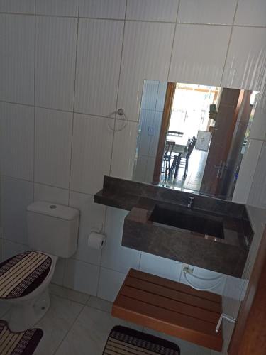 un bagno con un water, un lavandino e uno specchio di Sevenresidence a Barra Velha