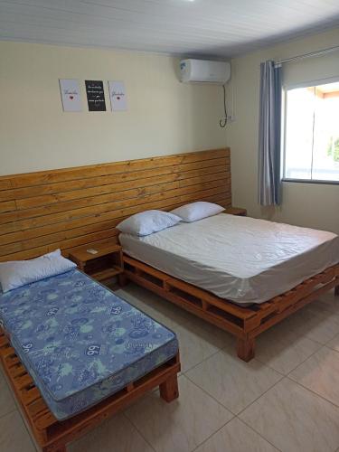 due letti singoli in una stanza con finestra di Sevenresidence a Barra Velha