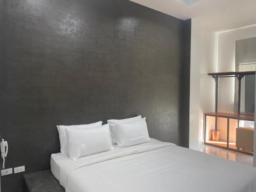 1 cama con almohadas blancas en una habitación en 22 Twenty-Two Hotel ทะเวนตี้-ทู โฮเทล, en Ban Pa Muat