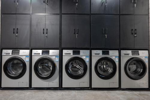 a row of washing machines in a laundry room at Dayin Youth Hostel - East Nanjing Road & People's Square & The Bund -Large Social Area -Bar -Café -Gym -Free Laundry Luggage Storage -24H Front Desk -English Service in Shanghai