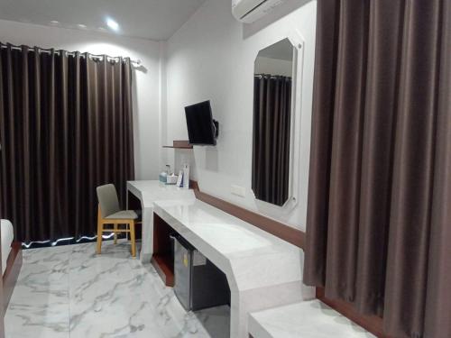 a hotel room with a bathroom with a sink and a mirror at สวนหินวิลล่า รีสอร์ท in Ban Chot