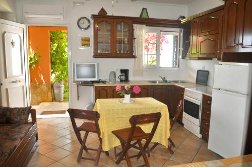 a kitchen with a table with a yellow table cloth at Villa Takis on Pelekas beach Apartment A with private garden and sea view in Pelekas