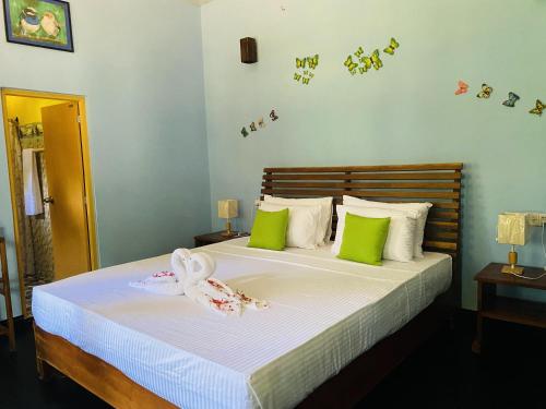 Sigiri Siesta Homestay في سيجيريا: غرفة نوم عليها سرير وفوط