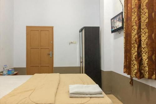 a bedroom with a bed with a towel on it at RedDoorz Syariah At Hotel Baruga Bonerate Selayar in Benteng