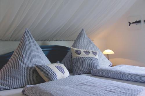 1 dormitorio con 2 camas y almohadas azules y blancas en Ferienhaus Landhaus Uttum, en Krummhörn