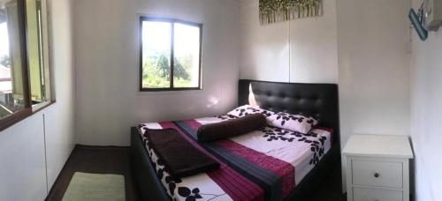 a bedroom with a bed and a window at Noungan Farm Homestay in Penampang
