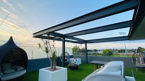 Elle offre une vue sur une terrasse dotée de chaises et d'une table. dans l'établissement Skypark on Vincent - EXECUTIVE ESCAPES, à Perth