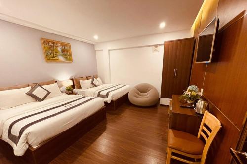 um quarto de hotel com duas camas e uma secretária em Villa Camellia em Da Lat