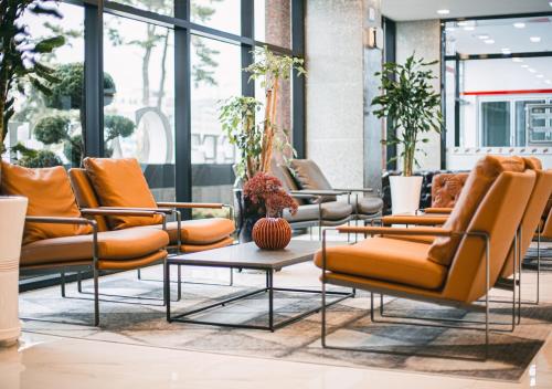 a row of chairs and tables in a lobby at Hotel Sweet Castle Jeju Hamdeok in Jeju