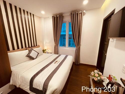 a hotel room with a bed and a window at Villa Camellia in Da Lat