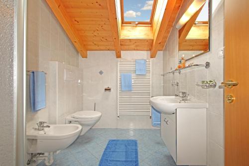baño con 2 lavabos, aseo y ventana en Obermairhof, en San Giacomo