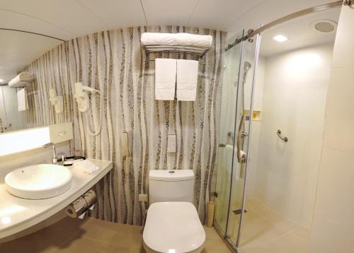 a bathroom with a toilet and a sink and a shower at South Pacific Hotel in Hong Kong
