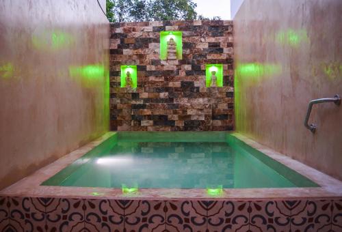 uma banheira de hidromassagem com luzes verdes numa parede de tijolos em Apartamentos Dsiena Valladolid em Valladolid
