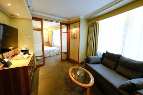 a living room with a couch and a table at South Pacific Hotel in Hong Kong